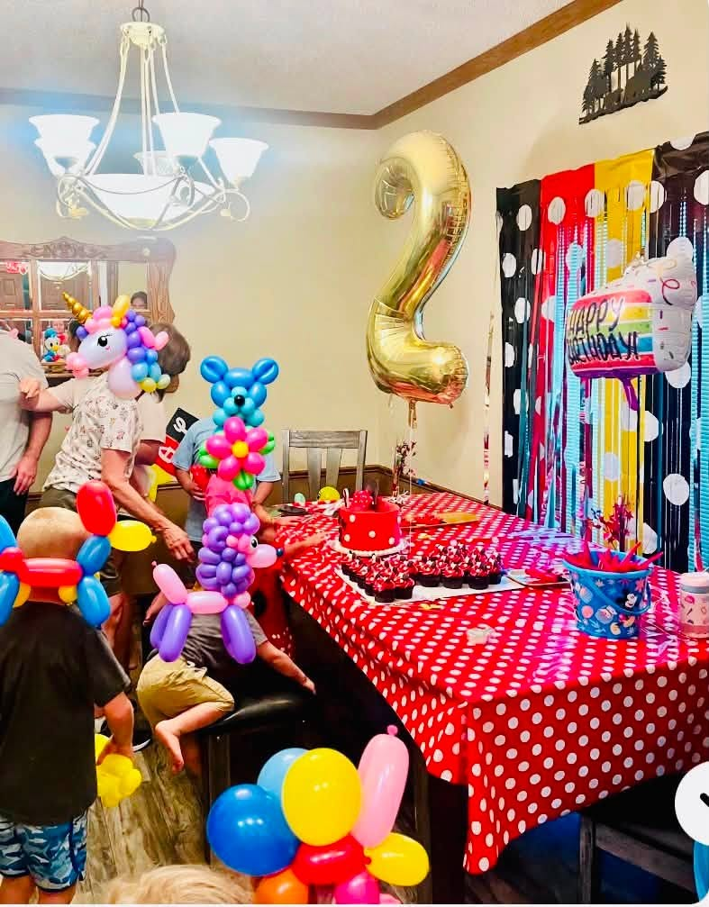 Kids wearing balloon unicorn and puppy hats at a birthday party